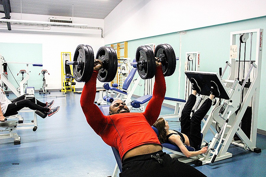 Мужчина поднимает гантели