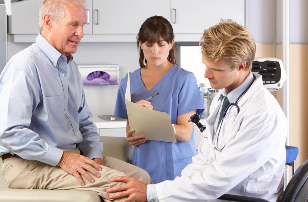 Доктор осматривает колено пожилого мужчины