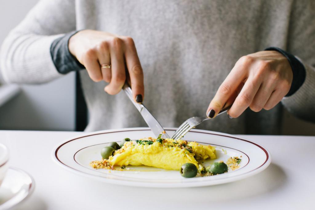 Девушка ест омлет