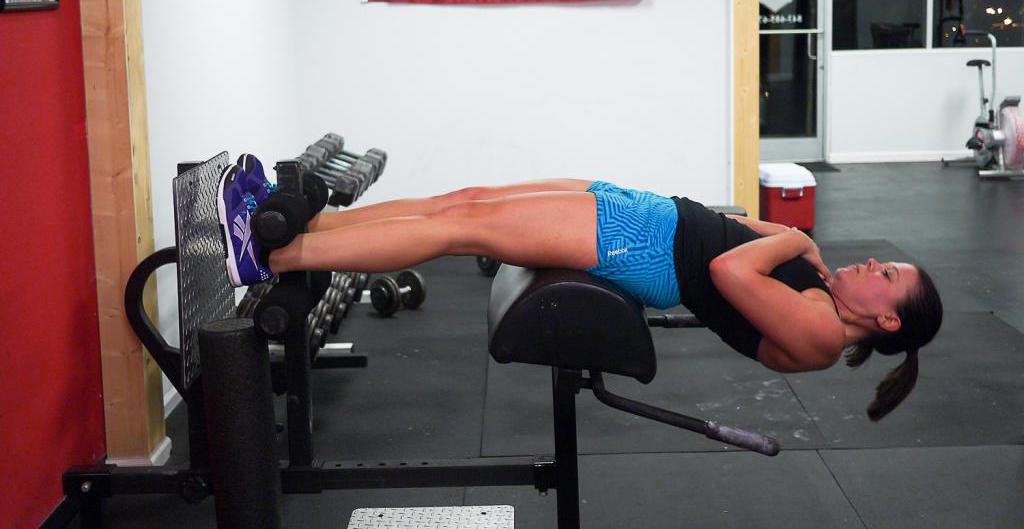 Женщина делает классическую гиперэкстензию