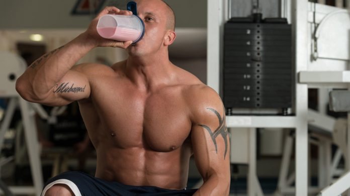 Культурист, пьющий креатиновый коктейль